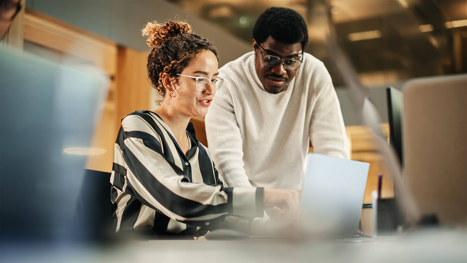 Coworkers reviewing the May 2026 jobs report on a laptop looking at April labor market trends.