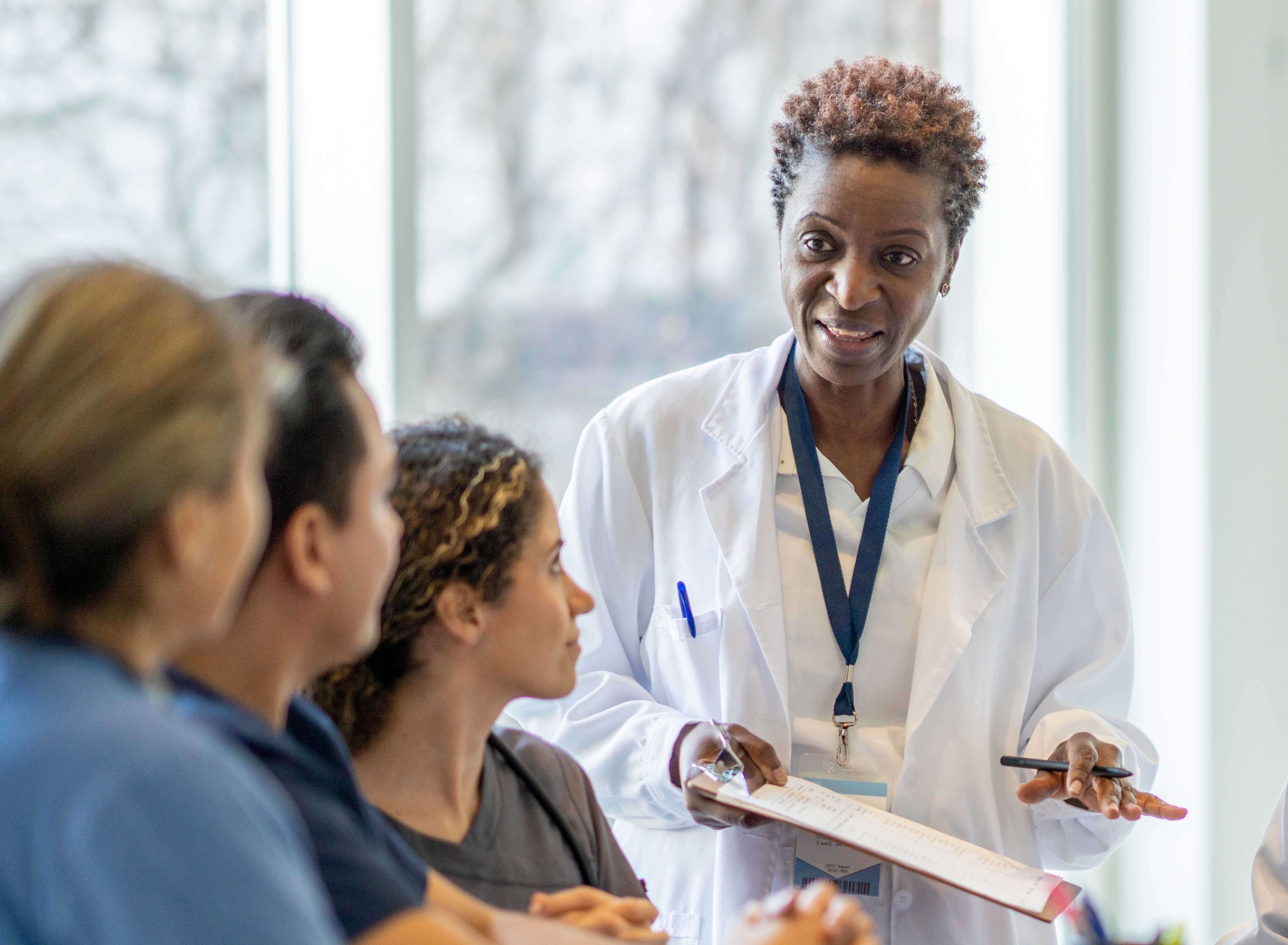 Female clinical worker discussing next steps with patients before clincal trial begins.