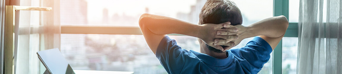 Man looking out from office over the city