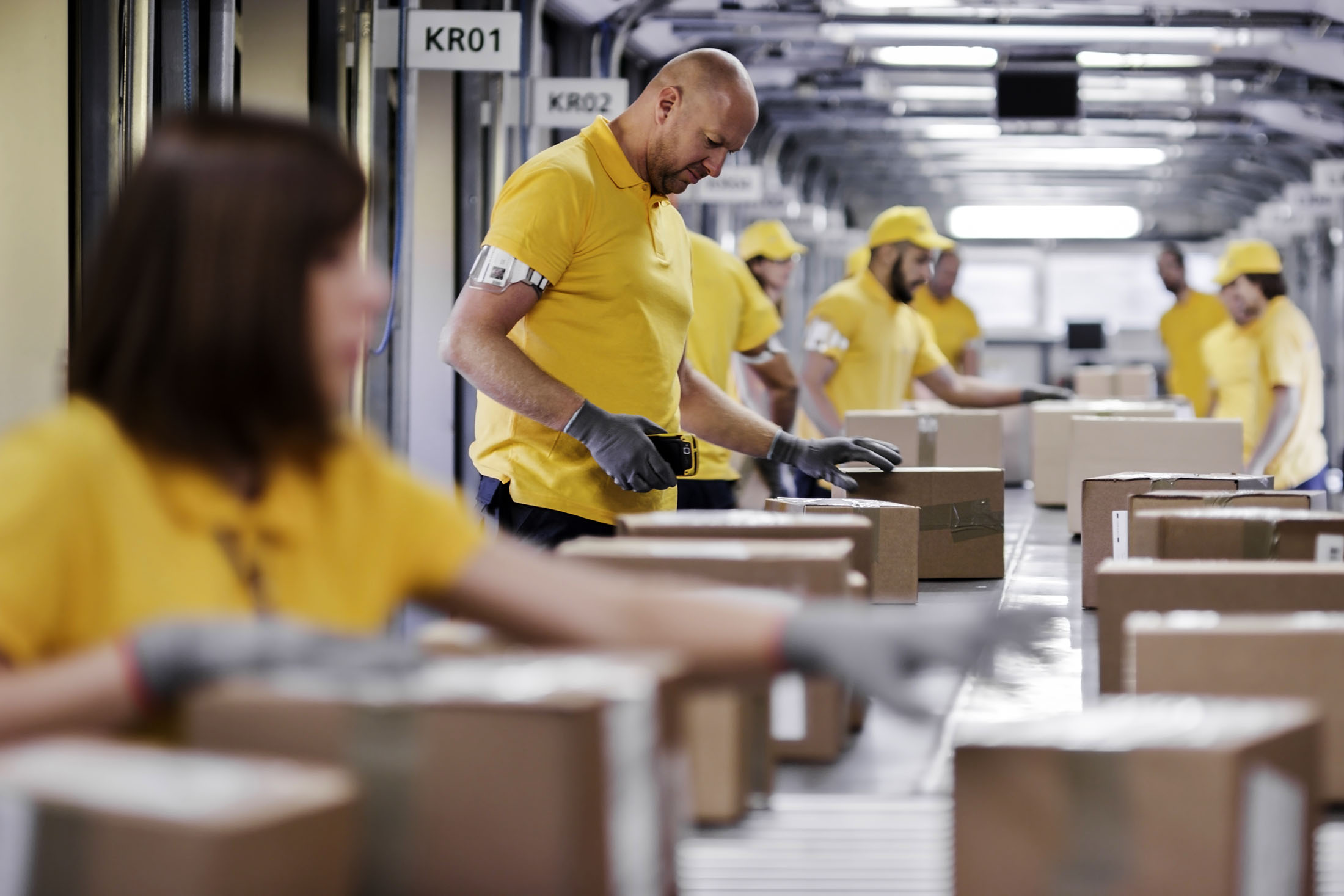 Workers processing boxes on assembly line