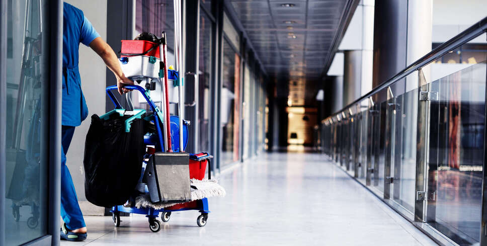 Nurse pushing vitals cart f rom hallway to room