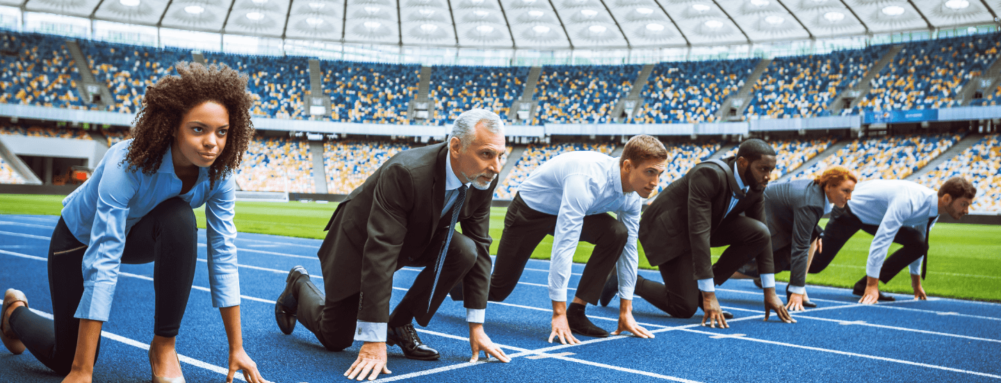 photo of people in professional outfits, lined up on a stadium running track and ready to race